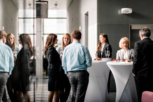 Professionals networking during a business event in a modern lobby, discussing startup licensing costs in RAK Free Zone.